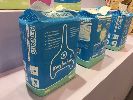 Kasbakas pet pads fitted under a cat litter box — live demo at the booth